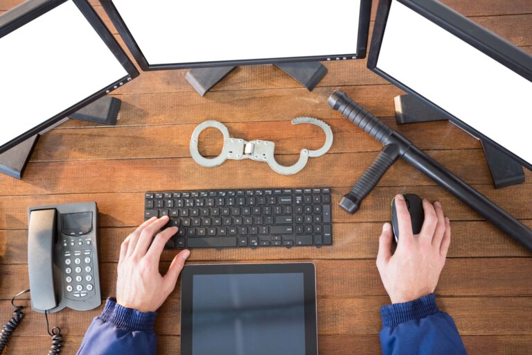 Hands of security officer using computer at desk