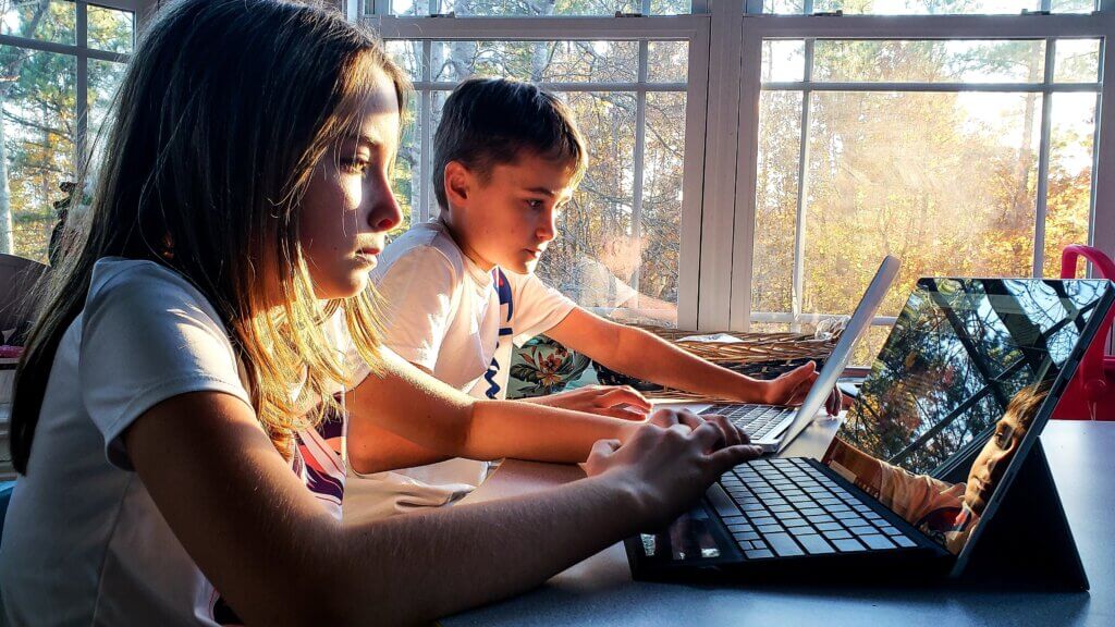 2 kinderen aan het werk op hun laptop op school voor een opdracht